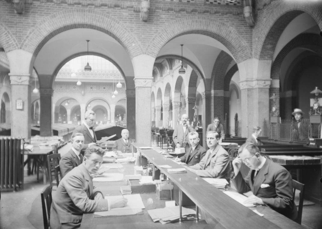 Interieurfoto van het pas geopende stadhuis. Ambtenaren van de bevolkingsadministratie aan het werk. Fotograaf Van Dijk. 1920 Collectie 4117. Documentnummer 2008-5179-04