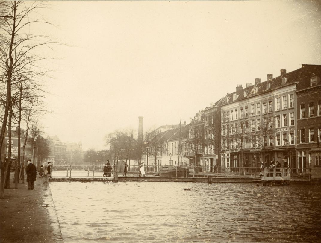 Coolvest en Comediebruggetje omstreeks 1910. Rechts, met een lantaren boven de deur en een tekstbord aan de gevel tussen de eerste en tweede verdieping, is Coolvest 44.