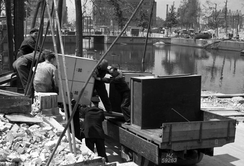 Geredde kluizen afkomstig uit de Bank voor Handel en Scheepvaart worden op en vrachtwagen geladen. Op de achtergrond de nog niet gedempte Blaak. Collectie 4156, nummer 5121