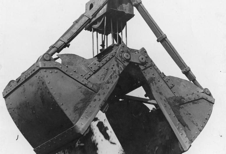 Detailopname van een grijper die goederen (mogelijk steenkool) lost (1928-1935).