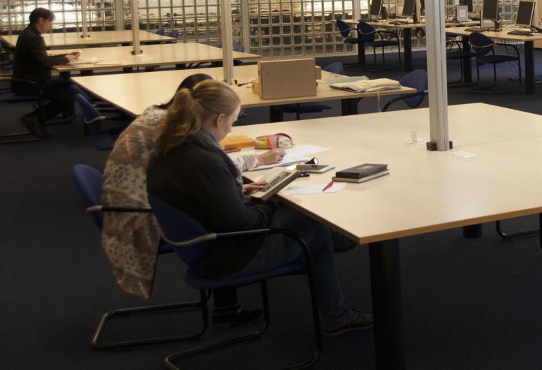 Mensen aan een tafel in de studiezaal
