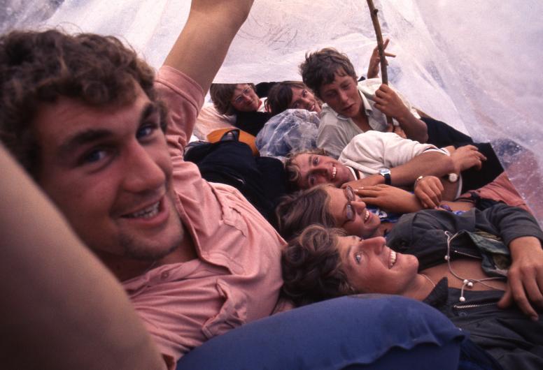 Jongeren schuilen voor de regen tijdens het Holland Pop Festival. Collectie 4100, nummer 47-029. Fotograaf Hajo Piebenga