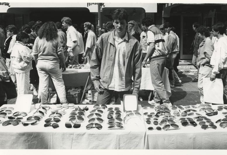 Man verkoopt zonnebrillen op de Vrijmarkt tijdens Koninginnedag, 1986. Foto Vrije Volk. Collectie 4282, 1986-863.
