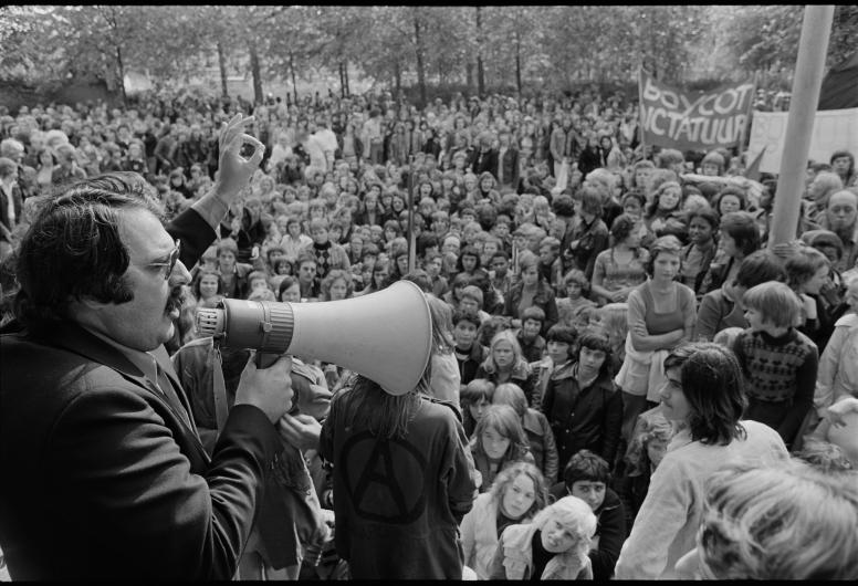 2 oktober 1975: Burgemeester Van der Louw spreekt op de trap van het Spaanse consulaat in de Delftsestraat scholieren toe die betogen tegen de Spaanse dictator Francisco Franco. Eerder waren de scholieren samengekomen op het Schouwburgplein. Het protest was onderdeel van een landelijke oproep om Spanje en het regime van Franco te boycotten en twee minuten stilte te houden voor de slachtoffers van dictatoriale regimes over de hele wereld. Foto: Ary Groeneveld, collectie 4121 25412-24-kl