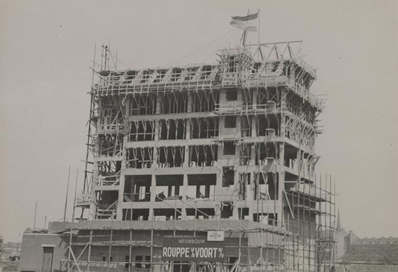 De bouw van het nieuwe bedrijfspand voor de industrie- en metaalmaatschappij Rouppe en van der Voort aan de Botersloot nummer 11 ontworpen door architectenbureau Kraaijvanger. In het gebouw komen kantoren, magazijnen en toonzalen. In de verte op de achtergrond is de nieuwe bebouwing, Wereldhaven (1942), aan de Goudsesingel te zien, 1947. Collectie 4135, WN-194