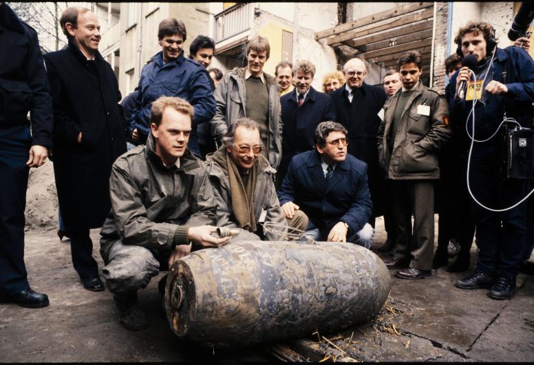 23 maart 1988  Burgemeester Peper poseert bij de opgegraven en gedemonteerde ‘Bellebom’ met medewerkers van de Explosieven Opruimingsdienst van Defensie. Foto: Rotterdams Nieuwsblad. Collectie 4190, 2-511-1-kl