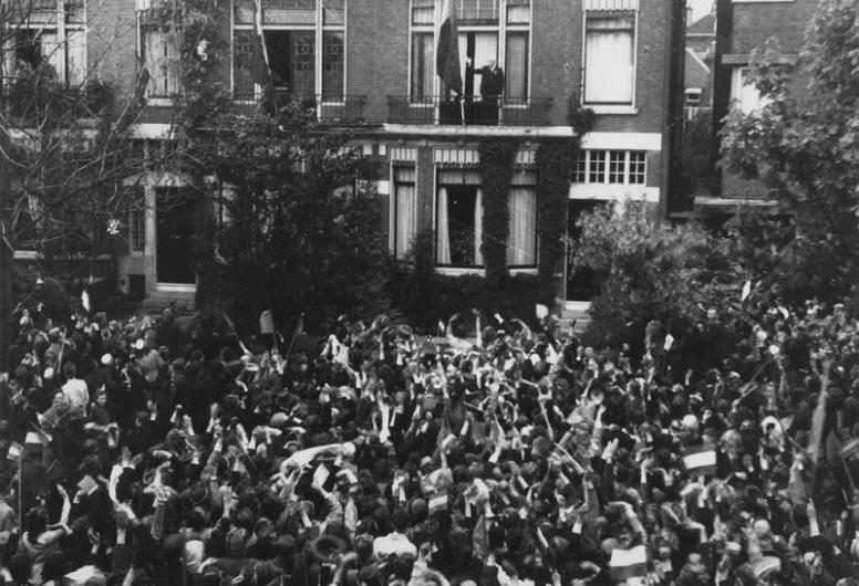 Burgemeester P.J. Oud, die op het balkon van zijn woning aan de Hoflaan de Nederlandse vlag heeft uitgestoken, wordt toegejuicht door de Rotterdamse bevolking, 06-05-1945. Johannes van Rhijn