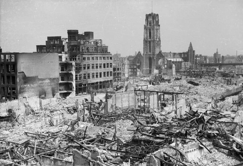 Restanten van gebouwen na het Duitse bombardement van 14 mei 1940. Overzicht vanaf het Erasmushuis: C &amp; A winkel op de hoek van de Hoogstraat en Korte Hoogstraat. Verder de Sint-Laurenskerk, mei 1940. Anonieme foto. Collectie 4100, nr. 1979-1491