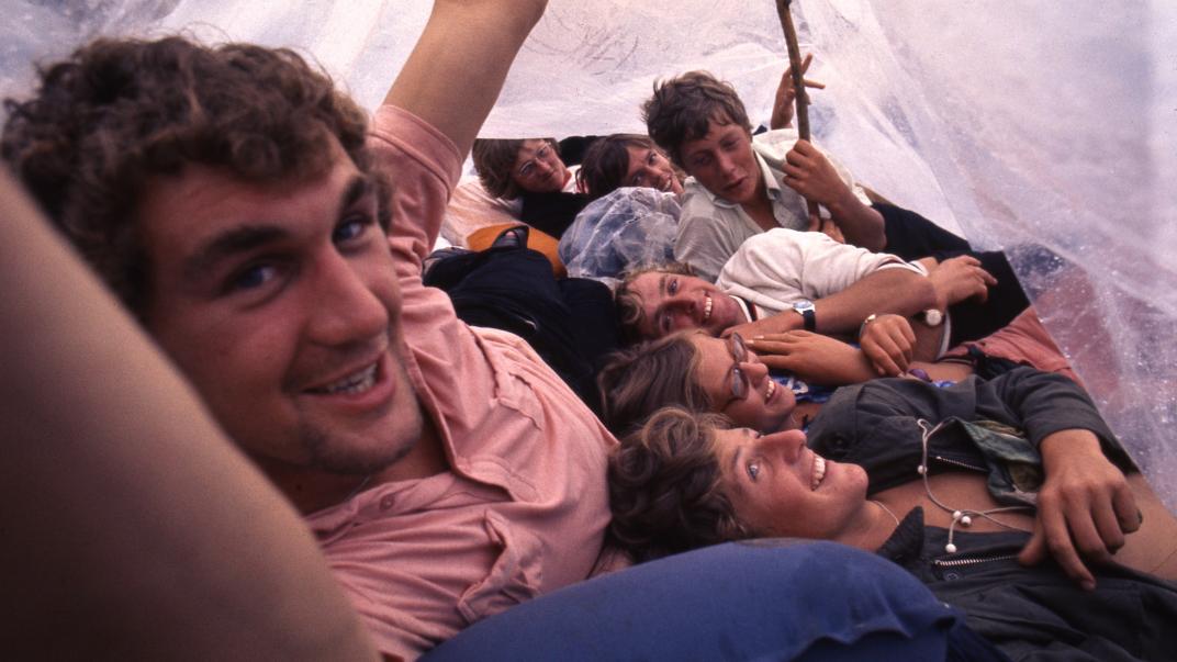 Jongeren schuilen voor de regen tijdens het Holland Pop Festival. Collectie 4100, nummer 47-029. Fotograaf Hajo Piebenga